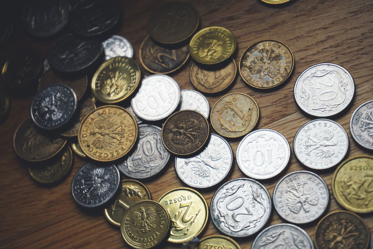 Close-up view of various Polish coins on a wooden table showcasing currency and finance concepts.